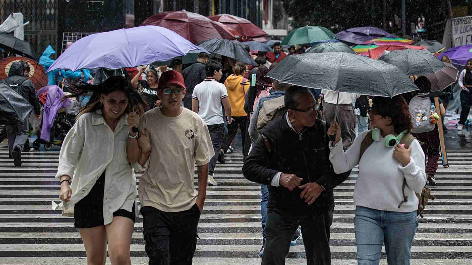 Personas se protegen de la lluvia en calles de la Ciudad de México.