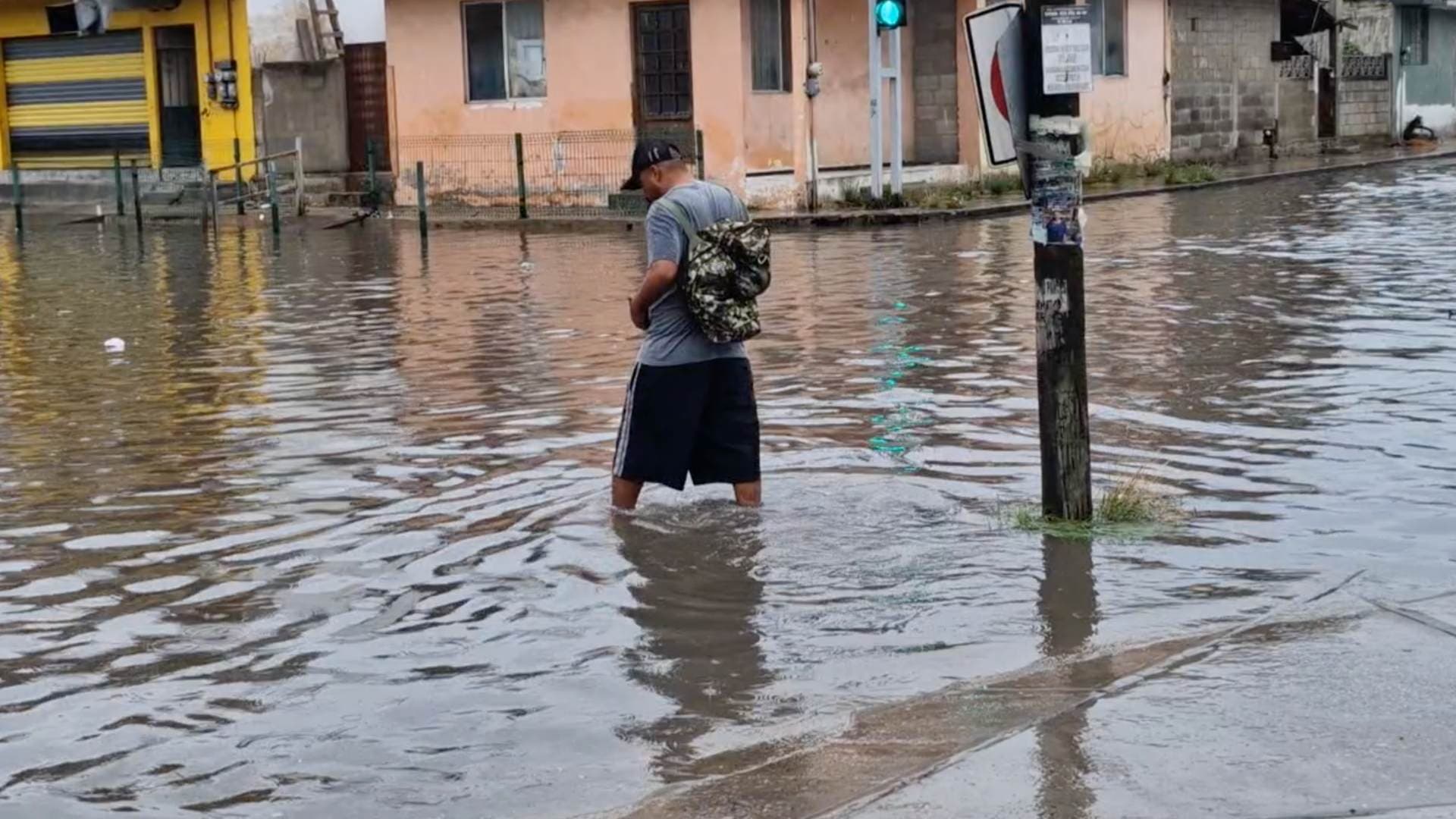 Hombre caminando en inundación en Ciudad Madero, Tamaulipas