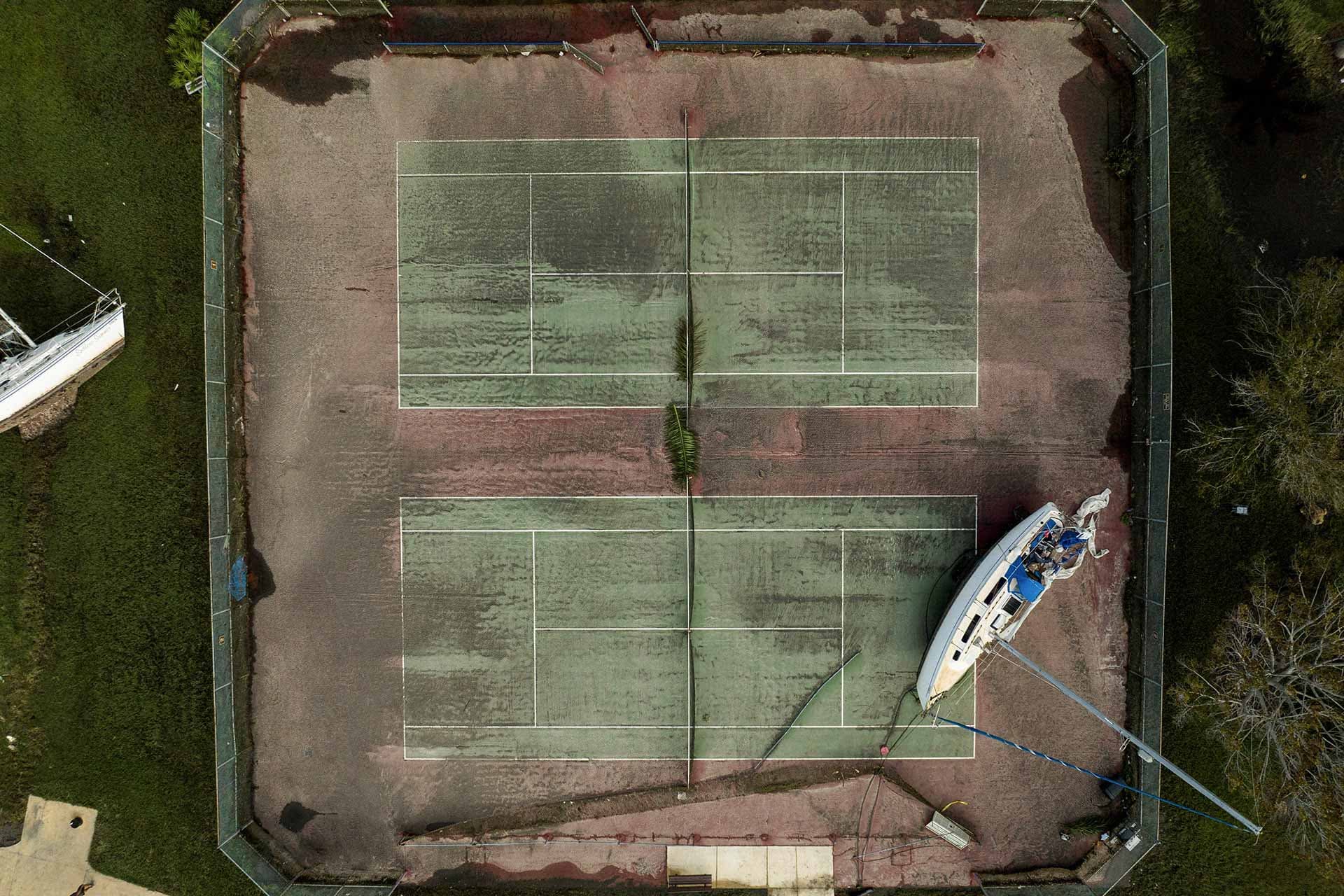 Un bote sobre una cancha de tenis después de ser arrastrado por el paso del huracán Milton en Florida