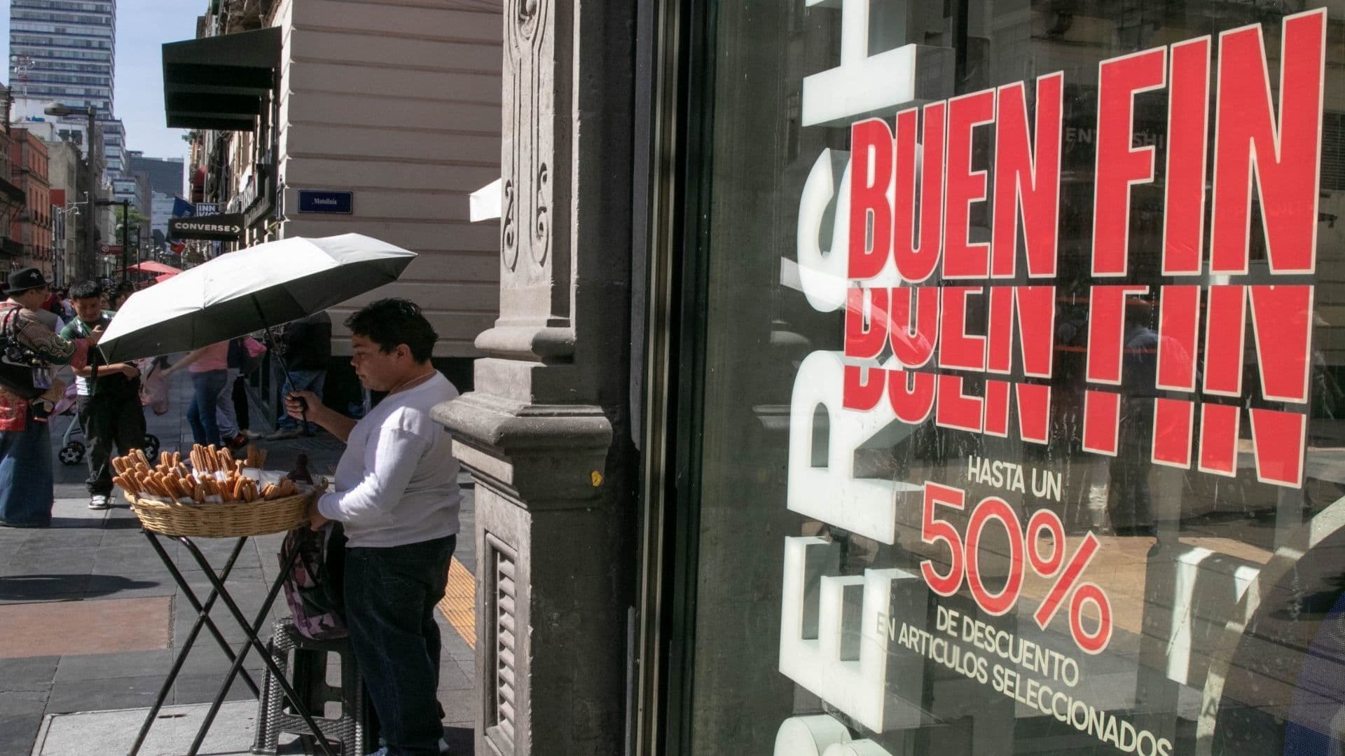 Una persona con una sombrilla y una mesa está vendiendo.