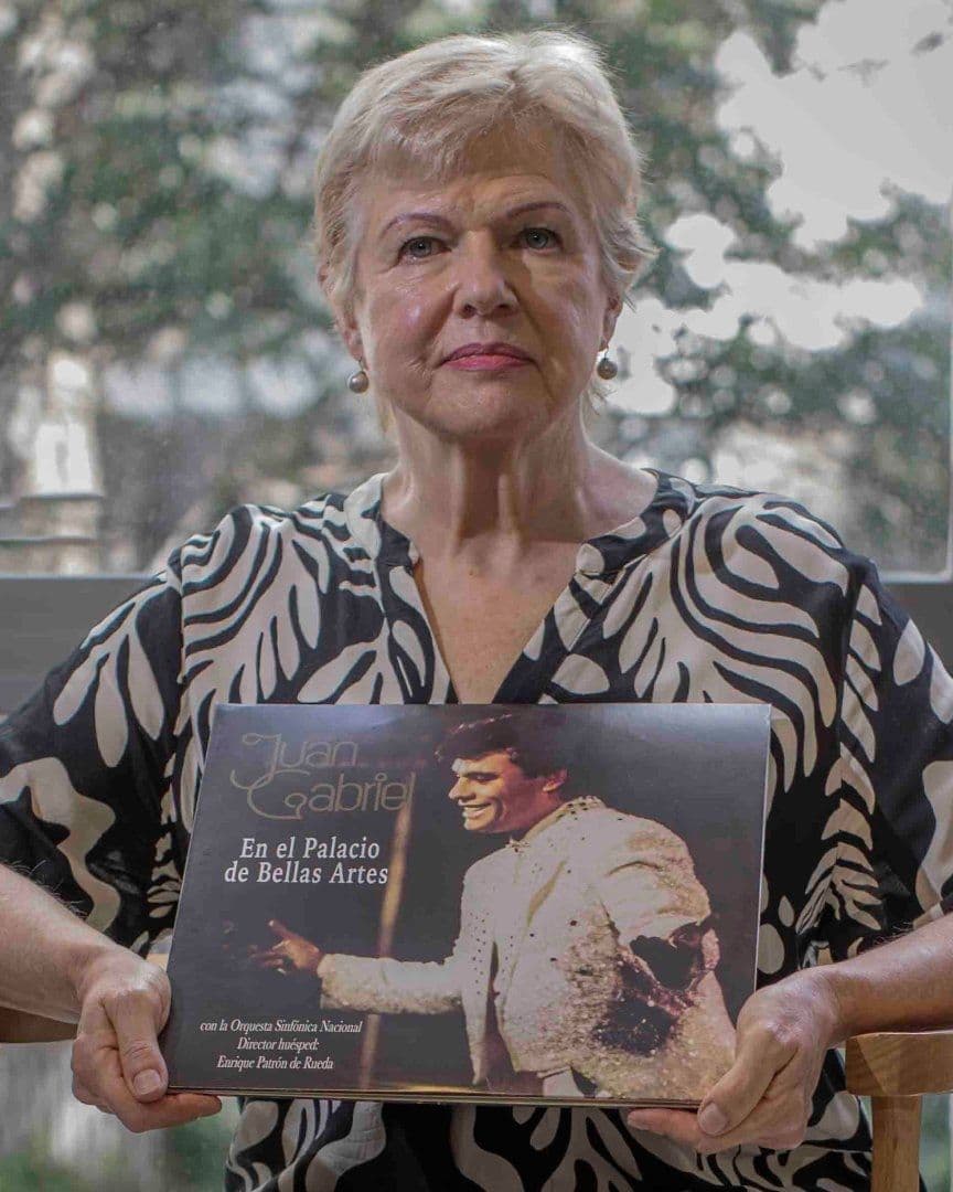 Una adulta mayor tiene una imagen de una imagen de Juan Gabriel.