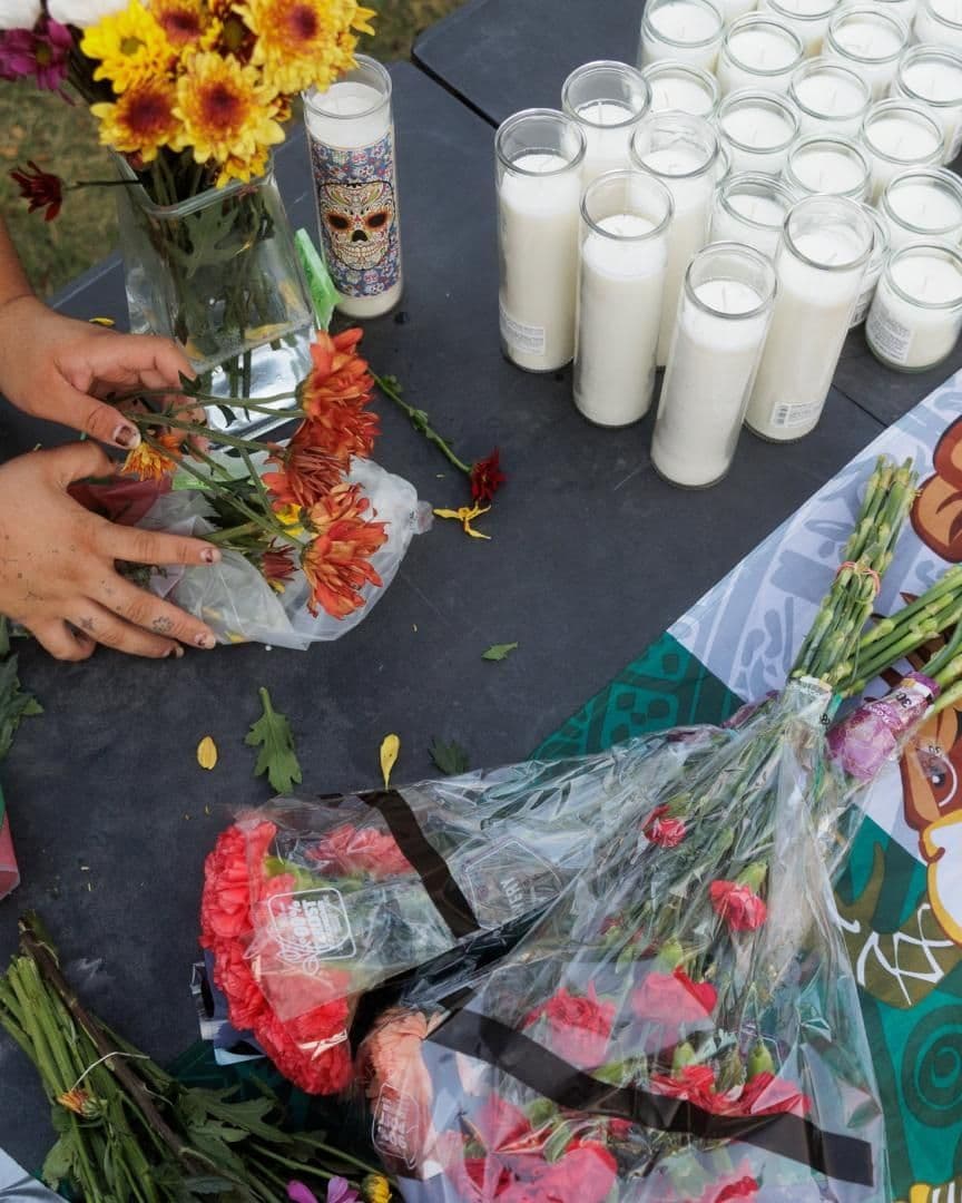 una bandera de México rodeada de flores y veladoras por mexicano que recibió disparos en sede de ICE, en Dallas