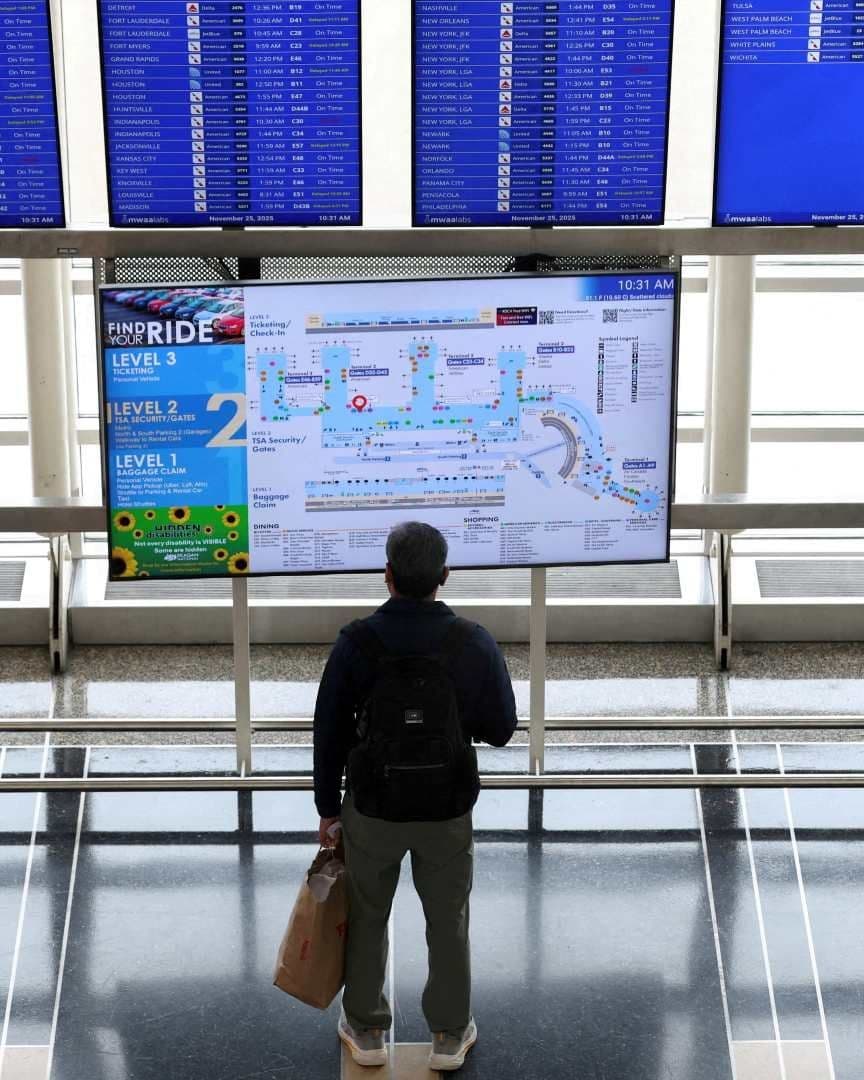 Pasajero mira panel de información de vuelos en el Aeropuerto Ronald Reagan de Washington, en noviembre 2025. Foto: Reuters