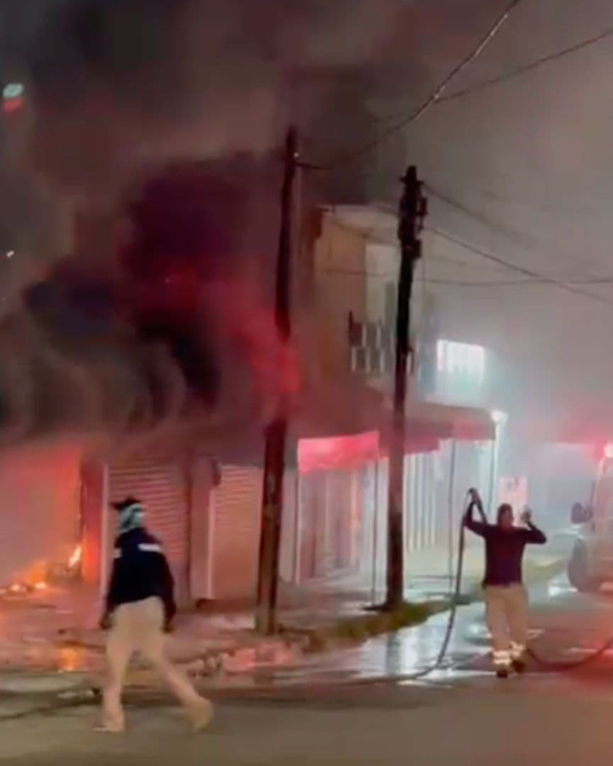 Bomberos combaten incendio en de locales comerciales atacados con bombas caseras en Acayucan.