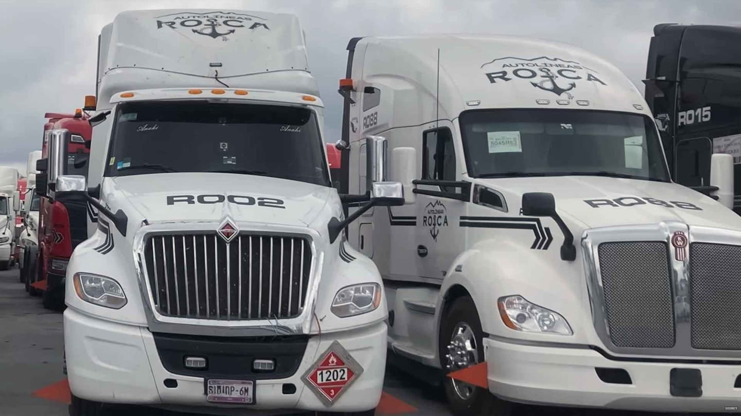 Dos camiones blancos tipo pipa vistos de frente con el logotipo de Autolineas Roca.